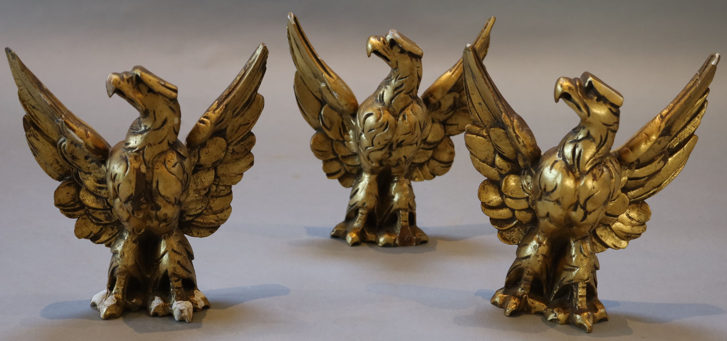 A set of three carved giltwood heraldic eagles, width 24cm height 26cm